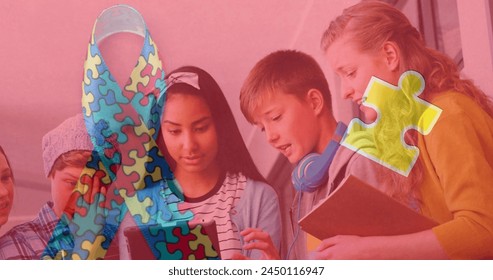 Image of colorful puzzle and ribbon over diverse children using tablet. Autism awareness month and children health concept digitally generated image. - Powered by Shutterstock