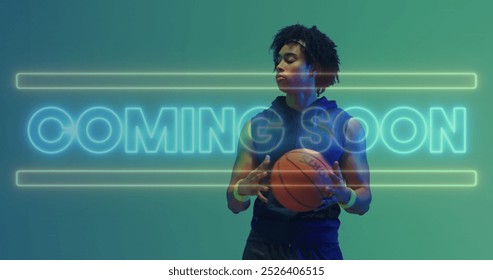 Image of coming soon text in neon over african american male basketball player holding ball. Sport, competition, skill, game, digital interface and communication digitally generated image. - Powered by Shutterstock