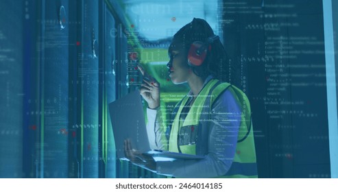 Image of computer language, african american female engineer checking server using laptop. Digital composite, multiple exposure, binary codes, coding, data center, technology concept. - Powered by Shutterstock