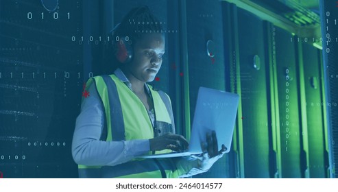 Image of computer language, african american female engineer using laptop in server room. Digital composite, multiple exposure, binary codes, coding, data center, technology concept. - Powered by Shutterstock