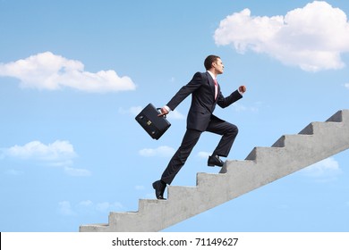 Image of confident businessman with briefcase walking upstairs