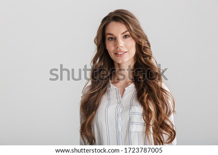 Image of confident caucasian woman posing and looking at camera isolated over white background