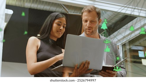 Image of connected computer icons forming globe over diverse coworkers analyzing data on laptop. Digital composite, multiple exposure, global network, business, teamwork, technology and office. - Powered by Shutterstock