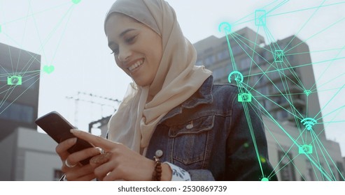 Image of connections and data processing over biracial woman in hijab using smartphone. Global business, finances, cloud computing and data processing concept digitally generated image. - Powered by Shutterstock