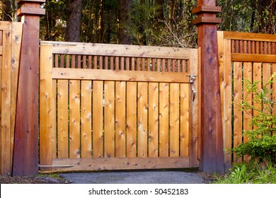 Image of a contemporary, decorative wooden gate as an entrance to a formal garden.