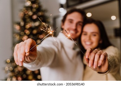 image of a couple celebrating christmas at home. Boyfriend and girlfriend spending time together on the new year evening and sharing positive vibes. Concept about love, holidays and lifestyle - Powered by Shutterstock