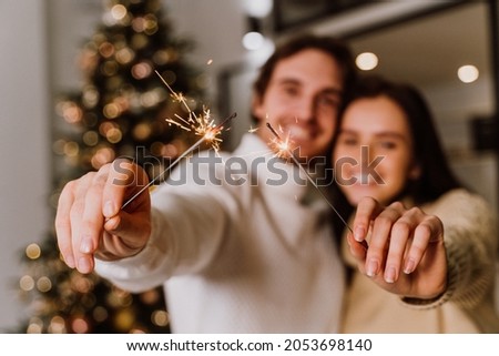 image of a couple celebrating christmas at home. Boyfriend and girlfriend spending time together on the new year evening and sharing positive vibes. Concept about love, holidays and lifestyle