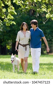 An Image Of Couple Walking Dog