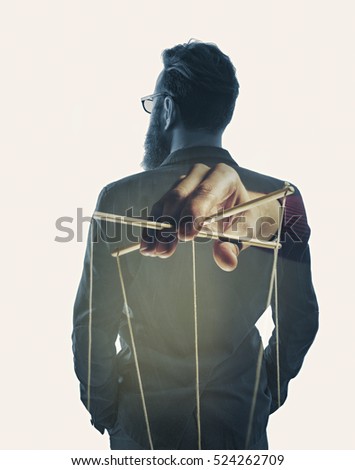 Image created using multiple exposures. Image of a hand, that manipulates of a man in a business suit.