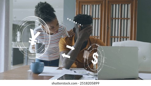 Image of currency icons data processing over worried african american couple paying bills. Global finance, connections, computing and data processing concept digitally generated image.