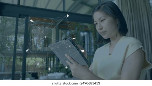 Image of currency signs, network and data processing over asian woman using tablet. Global finance, business, connections, computing and data processing concept digitally generated image. - Powered by Shutterstock