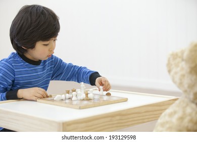 The Image Of Cute Asian Kid Playing Chess