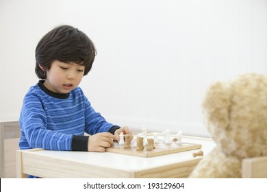 The Image Of Cute Asian Kid Playing Chess