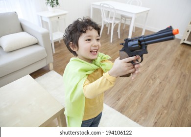 The Image Of Cute Asian Kid With Toy Gun