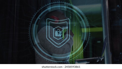 Image of cyber security text and padlock in circle, african american engineer checking data room. Digital composite, laptop, network security, data center, networking, technology, network server.
