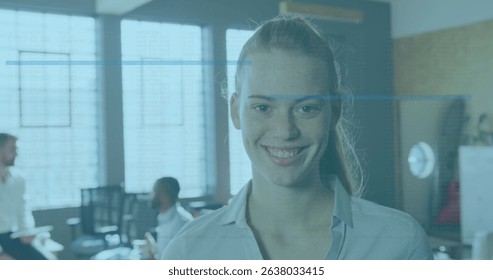 Image of data processing against portrait of caucasian woman smiling at office. Computer interface and business technology concept