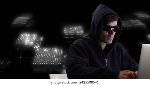 Image of data processing and caucasian male hacker using laptop on black background. Global business and digital interface concept digitally generated image.