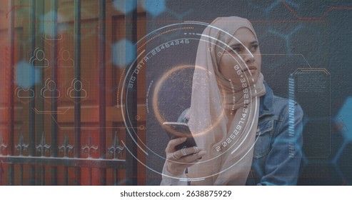 Image of data and processing circle over middle easters woman using smartphone. Finance, economy, communication and technology concept digitally generated image.