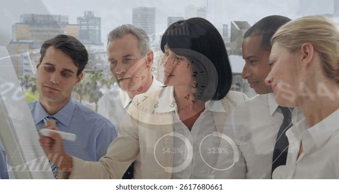 Image of data processing and clock over diverse business people taking notes. global business and digital interface concept digitally generated image.