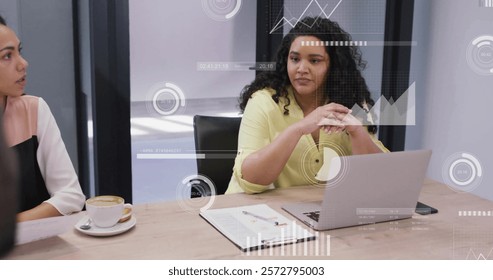 Image of data processing and diagrams over diverse colleagues discussing work in office. Technology, business and digital interface concept digitally generated image.