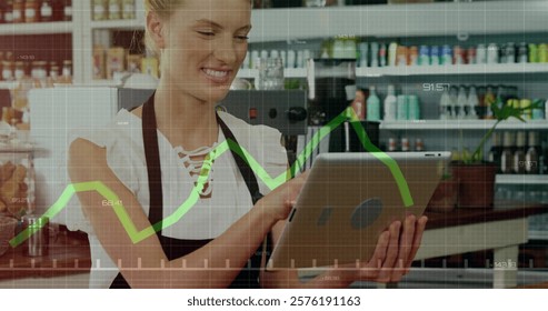 Image of data processing and diagrams over caucasian businesswoman using tablet in her cafe. Technology, business and digital interface concept digitally generated image.