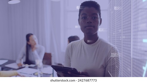 Image of data processing with numbers over african american businesswoman in office. Global business, digital interface, computing and data processing concept digitally generated image.