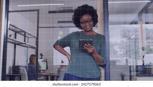 Image of data processing over african american businesswoman in office. Global business, digital interface, computing and data processing concept digitally generated image.
