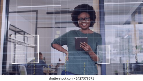 Image of data processing over african american businesswoman in office. Global business, digital interface, computing and data processing concept digitally generated image.