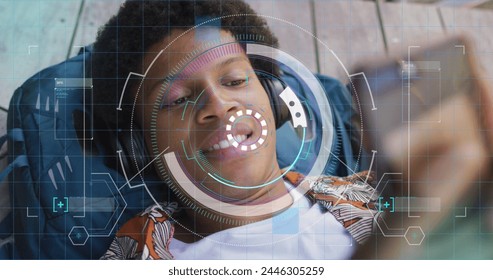 Image of data processing over african american man using smartphone. Global business and digital interface concept digitally generated image.