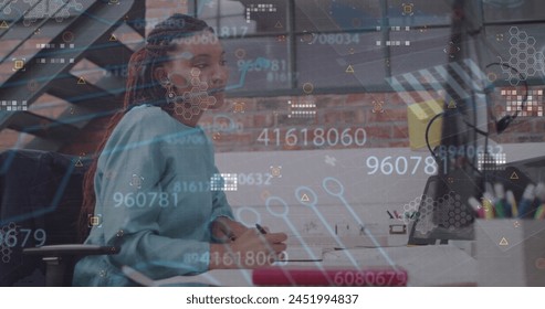 Image of data processing over african american businesswoman using computer. Global business and digital interface concept digitally generated image.