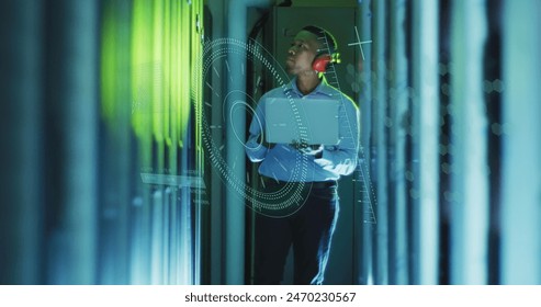 Image of data processing over african american male worker with laptop in server room. Global business, security and digital interface concept digitally generated image.