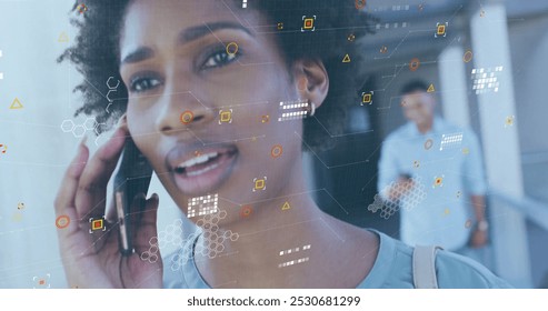 Image of data processing over african american woman with takeaway coffee talking on smartphone. Data, networks, digital interface, convenience and communication, digitally generated image.