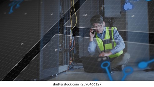 Image of data processing over asian worker using laptop and smartphone in server room. Global business, communication, computing and digital interface concept digitally generated image.