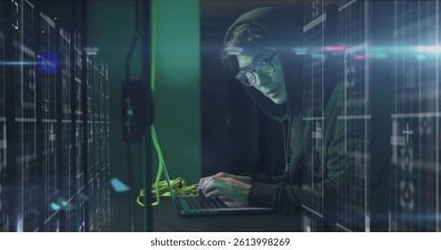 Image of data processing over asian male hacker in hoodie with laptop by computer servers. online cyber attack, cloud computing concept and technology concept digitally generated image.