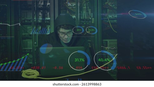 Image of data processing over asian male hacker in hoodie with laptop by computer servers. online cyber attack, cloud computing concept and technology concept digitally generated image.