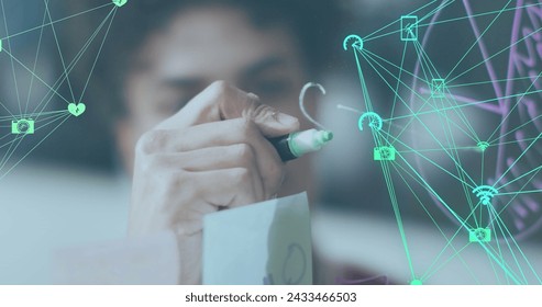 Image of data processing over biracial businessman taking notes on glass wall. Global business and digital interface concept digitally generated image.