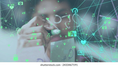 Image of data processing over biracial businessman taking notes on glass wall. Global business and digital interface concept digitally generated image.