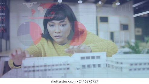 Image of data processing over biracial businesswoman working in architect's office. Global business, finances, computing and data processing concept digitally generated image.