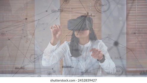 Image of data processing over biracial businesswoman using vr headset. Global business and digital interface concept digitally generated image.