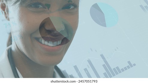 Image of data processing over biracial female doctor smiling. global medicine and digital interface concept digitally generated image.