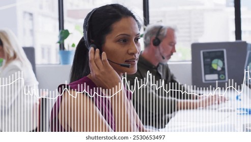 Image of data processing over biracial businesswoman using phone headset in office. Business, communication, technology, computing and digital interface concept digitally generated image.