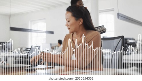 Image of data processing over biracial businesswoman working in office. Business, communication, technology, computing and digital interface concept digitally generated image. - Powered by Shutterstock - Get 15% off with code: PIKWIZARD15