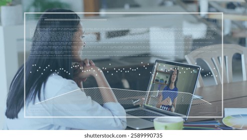 Image of data processing over biracial businesswoman using laptop for image call in office. Global business, finances and digital interface concept digitally generated image.