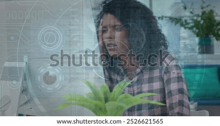 Image of data processing over biracial businesswoman using phone headphone in office. Global business, finance, computing and data processing concept digitally generated image.
