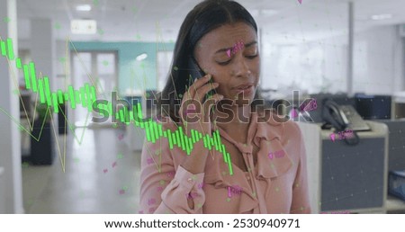 Image of data processing over biracial businesswoman working in office. Global business and digital interface concept digitally generated image.