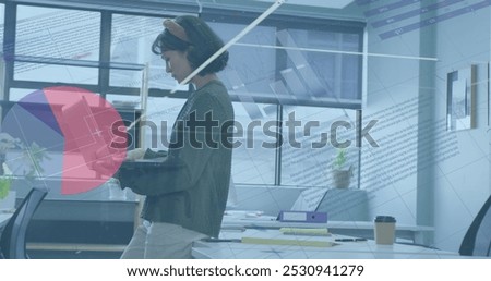 Image of data processing over biracial businesswoman working in office. Global business and digital interface concept digitally generated image.