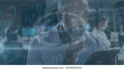 Image of data processing over businessman using tablet in office. global business, connections, data processing and technology concept digitally generated image.