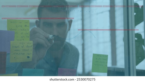 Image of data processing over caucasian businessman taking notes. global business, finances, connections and digital interface concept digitally generated image.