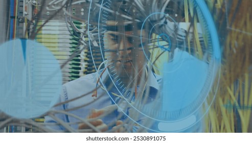Image of data processing over caucasian male engineer connecting wires. computers, network, data processing, technology and digital interface concept digitally generated image.