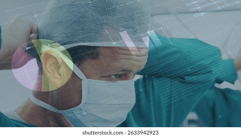 Image of data processing over caucasian male surgon wearing face mask. Global medicine and digital interface concept digitally generated image.